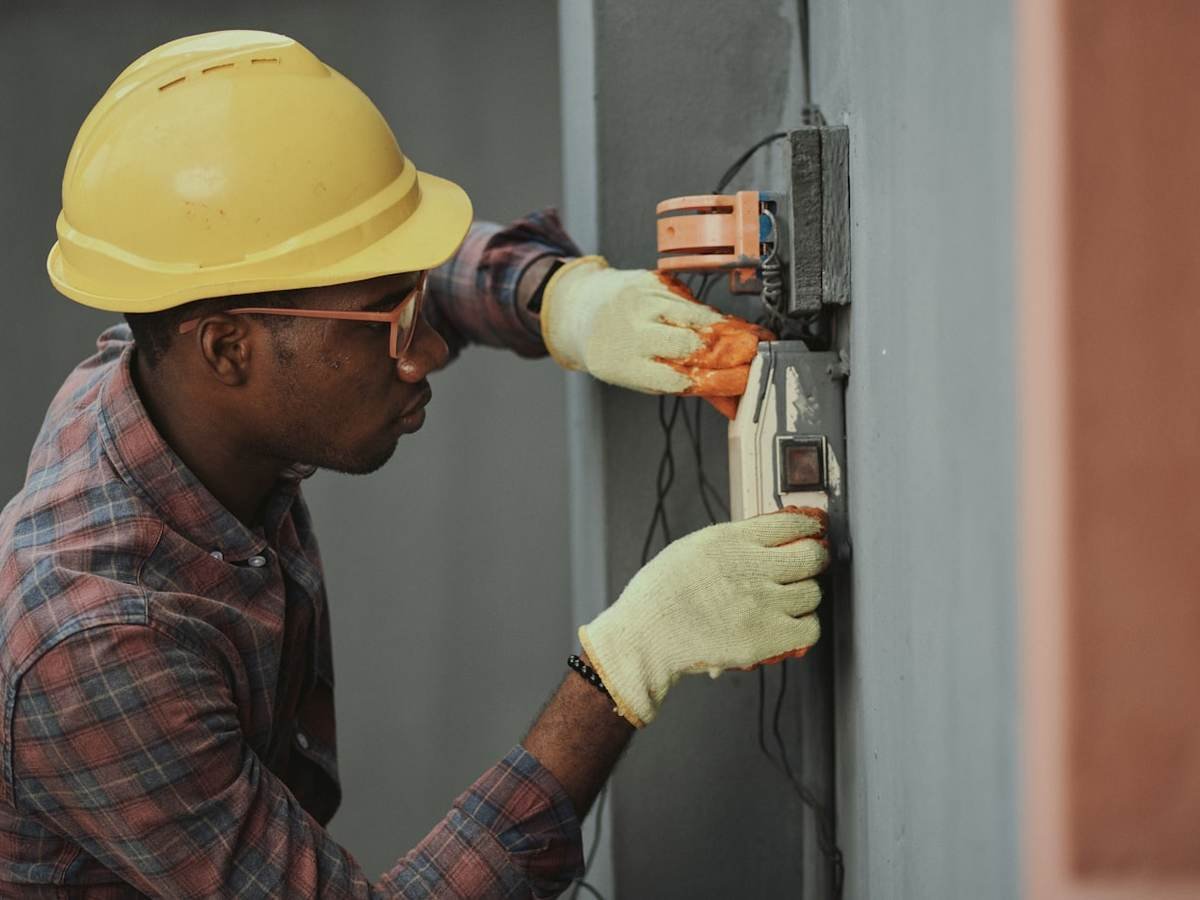 An electrician testing inside an open switchboard