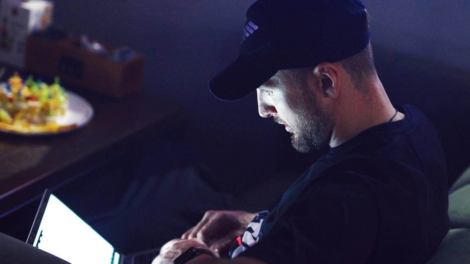 A tradesperson working on a laptop late at night